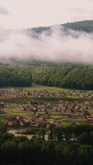 Hemu village on Kanas Nature Reserve, enveloped in fog. - obrazy, fototapety, plakaty