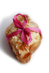 Sweet Easter cake named Colomba Pasquale (Easter dove) with pink tied bow isolated on white background. Italian traditional pastry 