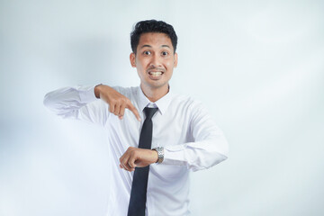 Adult Asian man showing angry face expression while pointing to his arm watch	
