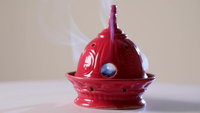 The red censer spins, filled with burning incense