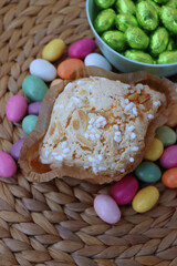 Sweet Easter cake named Colomba Pasquale with colorful chocolate eggs. Italian traditional pastry on wooden table