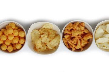 Top view of white ceramic bowls with different kind of chips in a row isolated on white background