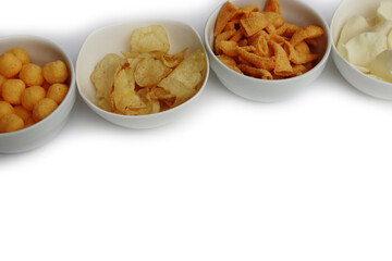 Top view of white ceramic bowls with different kind of chips in a row isolated on white background