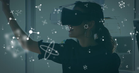 Image of molecules over caucasian woman wearing vr headset in office