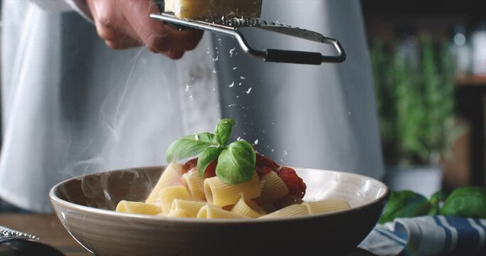 Extreme slow motion macro of raw loaf of dough falling with flour dust splashes while artisan baker chef making homemade bread, pasta or pizza on rustic wooden table in traditional bakery kitchen 