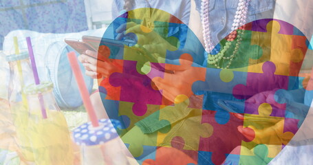 Image of colourful puzzle pieces heart over friends sing smartphone and tablet