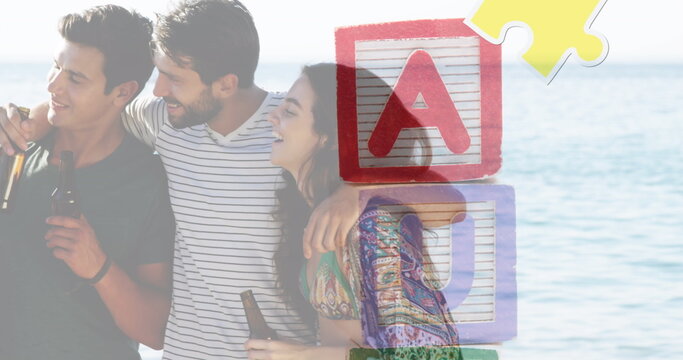 Image of colourful puzzle pieces and autism text over happy friends at summer beach party