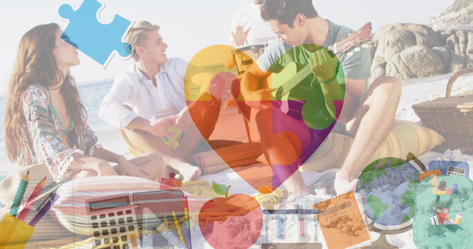 Image of colourful puzzle pieces and school icons over happy friends at summer beach party