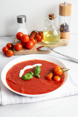 fresh tomato soup in a white bowl. on a white background
Tomato soup with basil and olive oil on a white background.