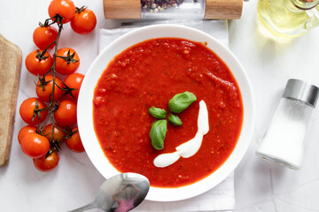 fresh tomato soup in a white bowl. on a white background
Tomato soup with basil and olive oil on a...