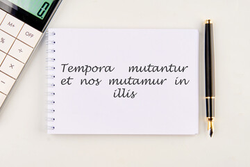 Tempora mutantur et nos mutamur in illis Translated from Latin, it means Times are changing, and we are changing with them. on a white notebook