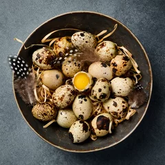 Foto op Plexiglas Clay bowl with fresh quail eggs. Quail feathers. Top view. © Yaruniv-Studio