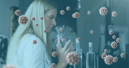 Image of coronavirus cells flowing over a female laboratory worker examining samples