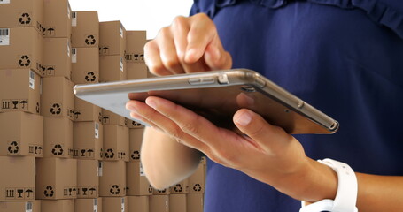 Image of man using tablet with stacks of boxes on white background