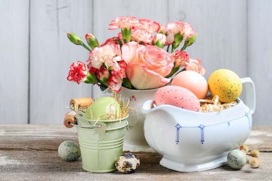 Easter decoration with painted eggs and bouquet of flowers.