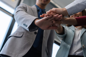 Close up view from top businesspeople putting hands together above the table express unity and support. Symbol gesture of friendship togetherness and like-minded people concept.