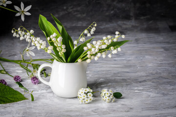 Bouquet spring white Lily of the valley. Floral still life on gray wooden board table in rustic style. Blooming branch bush with flowerbed gardening flower-growing.