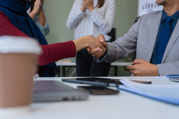 Happy businessman and businesswoman shaking hands at group board meeting. Professional business executive leaders making handshake agreement successful company trade partnership handshake concept.