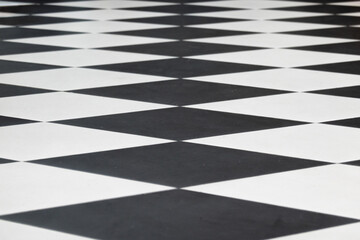 Close-up perspective of a floor in a public space. There are black and white elements. Background.