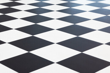 Top view of a floor made of large black and white ceramic tiles. Arranged in a checkerboard...