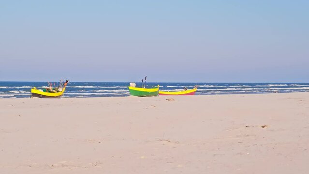 Undecked Handliner Fishing Vessel with Net Flags and Rusty Hooks Purse Sein Equipment Parked on Beach Sand at Seashore on Windy Spring Day