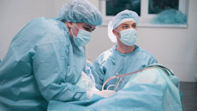 The doctor performs gynecological surgery using special equipment. The surgeon watches the screen.