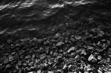 Sunlight reflecting off rocks in pond water