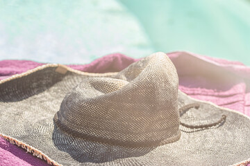 Sun hat lying on a towel near the pool - 757896970