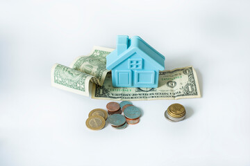 mockup of a blue plastic house and old worn paper $1 bills and coins on a white background.
