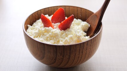Bowl of cottage cheese adorned with fresh strawberries spooning creamy dessert goodness Enjoy dessert indulgence of cottage cheese paired with luscious strawberries in this delightful dessert treat