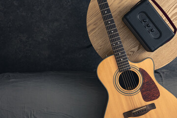 Acoustic guitar and speaker on the table, top view, copy space.