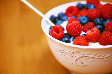 Closeup, berries and bowl with yogurt, raspberry and blueberry for organic snack. Food, cuisine and breakfast for health, wellness and diet for morning nutrition and antioxidant wellbeing in studio