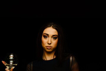 a young woman in an elegant dress with a glass of wine in her hand