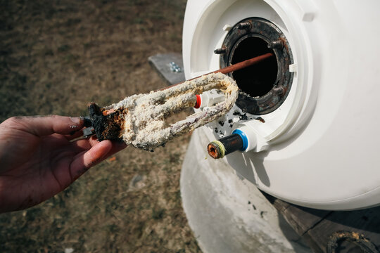 Replacing a heating element damaged by scale and limescale. Repair and maintenance of storage water heater. Scale and deposits on the heating element.