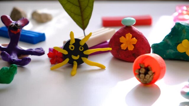 Child making crafts using natural dry plants, flowers, grass, leaves and use plastic corks, stones, plasticine, beads and paper. Back to school. Making diorama. Ideas for children's art