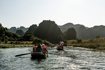 Tourists float down a river amid limestone mountains in Tam Coc, northern Vietnam.
