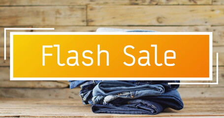 Image of flash sale text over denim trousers on wooden background