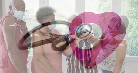 Image of stethoscope and heart over senior diverse people wearing face masks