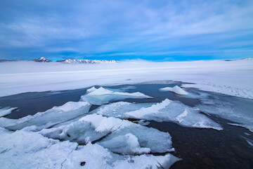 青空の下の氷の湖。湖面の割れた氷。北海道の屈斜路湖。