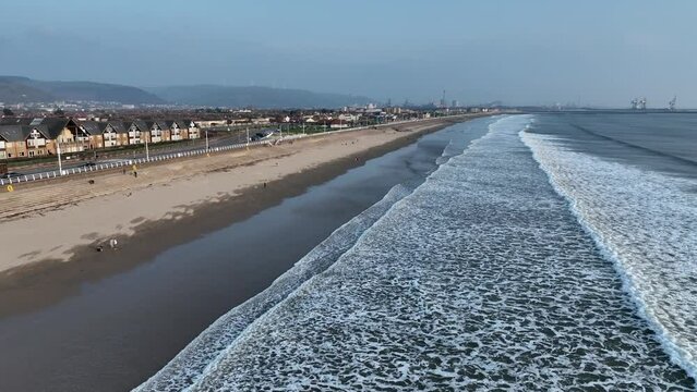 Editorial Port Talbot, UK - March 08, 2024: Aberavon beach in Port Talbot, South Wales UK and the Sandfields housing estate with the Tata Steel Works in the far distance.