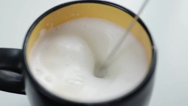 Milk is whipped into foam, frothing for cappuccino, coffee preparation, barista tool