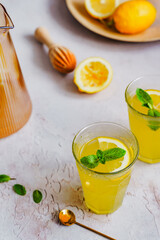Selbstgemachte Zitronen Limonade in zwei Gläsern auf einem grauen Tisch. Nahaufnahme. 