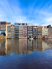 Traditional Dutch construction buildings on Damrak canal in Amsterdam in winter