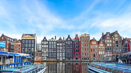 Obraz premium Traditional Dutch construction buildings on Damrak canal in Amsterdam in winter