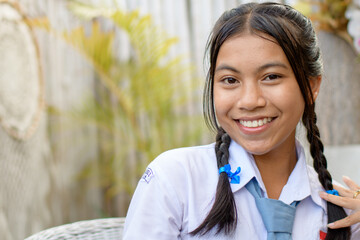 Smiling schoolgirl in uniform with ponytails