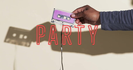 Image of party text over hand holding tape on beige background