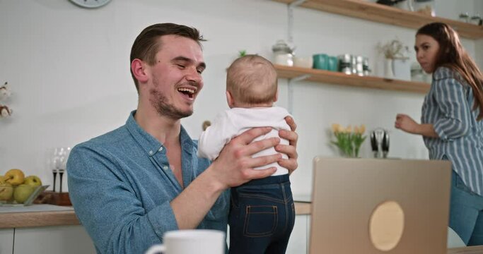 Playful Family Time: Dad Laughs as Baby Has a Little Accident at Home
