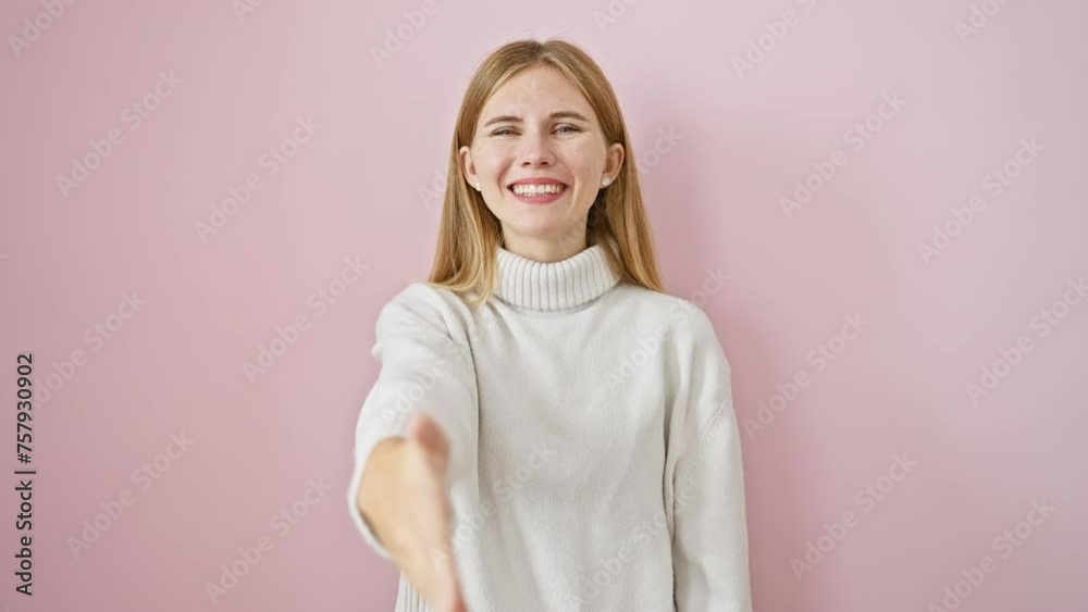 Canvas Prints Beautiful blonde girl offering friendly business handshake, greeting with a smile. standing successful over pink isolated background.