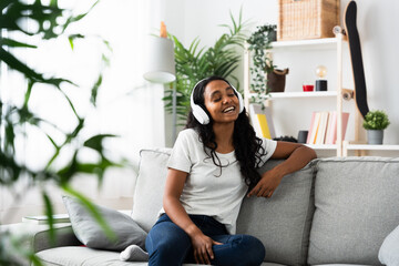Indian woman singing while listening to music on headphones.