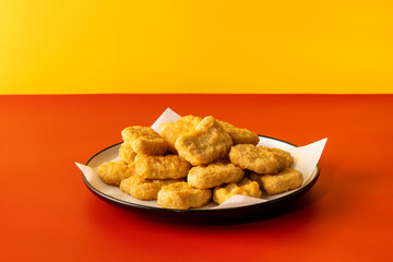 Delicious golden chicken nuggets on a plate on the table. Fast food, menu.